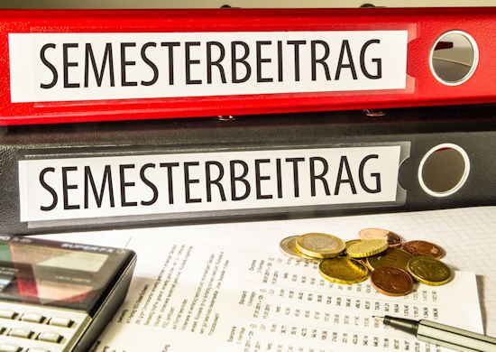 Ordner mit Aufschrift SEMESTERBEITRAG, davor Taschenrechner, Geldmünzen und Unterlagen